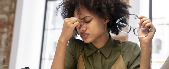 Pessoa em ambiente de trabalho sob pressão, simbolizando estresse emocional e mental
